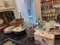 Overall view of kitchenware items and picnic basket on black counter