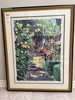 Full view of framed print showing garden scene with flowers and foliage, framed in gold and black bordered frame with white matting.