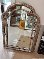 Front view of the ornate framed mirror showing full shape and frame details.