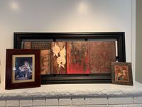 Wide shot of the large multilevel print in black wooden frame with two smaller framed pieces, all displayed on a white mantle.
