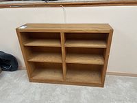 Front view of solid wood bookshelf showing six shelves with natural wood finish.