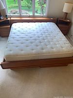 Front view of assembled king size platform bed frame with mattress showing headboard and underbed drawers