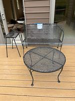 Full view showing all three pieces: loveseat, round coffee table, and square side table on wooden deck outside