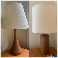 Two Danish Modern style table lamps side by side showing the wooden bases and cream fabric shades.
