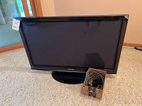 Panasonic 40 inch plasma HDTV with stand, black screen, placed on carpeted floor with attached price tag visible on side.