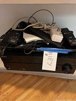 Front view of the Sony AV Receiver and Blu-ray player with remotes, cables, and power adapter on top.