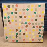 Full view of square abstract painting with colorful polka dots arranged in rows on light background