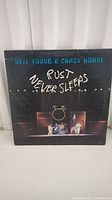 Front cover of the "Rust Never Sleeps" vinyl record showing Neil Young & Crazy Horse performing on stage with title in blue and white text.