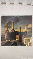 Front cover of Pink Floyd The Animals album showing Battersea Power Station with flying pig balloon. Shows wear and damage on edges and corners.