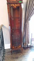 Front view of full curio cabinet showing overall form and finish