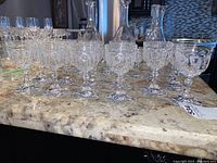 Row of assorted crystal stem glasses on countertop showing both sizes