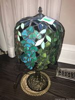 Full view of lamp on floor next to curtain showing entire shade and base