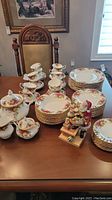 Full view of complete dinnerware components including plates, bowls, cups, accessories and Santa figure