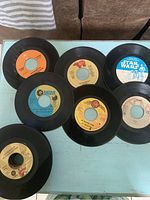 Top view showing a variety of 45 RPM vinyl records with different labels including MGM, RCA, and a Star Wars record.