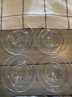 Top view of four clear glass chip and dip bowls on wood surface.