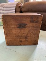 Front view of the wooden cigar box, showing latch and wood grain.