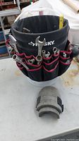 Front exterior view of black Husky bucket tool bag with visible hand tool pockets and tools