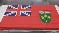 Full view of the Flag of Ontario spread out with visible Union Jack and shield.