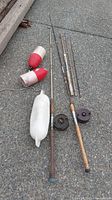 Overview of fishing gear on ground showing rods, reels, and float bobbers