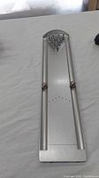 Full view of the silver-colored metallic mini bowling game including base, balls and pins