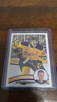 Photo of Connor McDavid rookie hockey card in yellow Edmonton Oilers uniform numbered 97, encased in a clear plastic card holder.