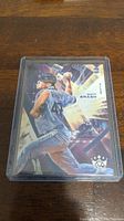 Image of Matt Brash rookie baseball card in protective case, showing player in pitching pose with detailed graphics and rookie card logo