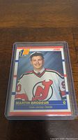 Close-up photo of the Martin Brodeur rookie card in a plastic protective case showing the player portrait, team, and rookie indicator.