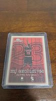 Front image of Michael Jordan 'mj exclusives' basketball card encased in clear plastic holder, showing red background with number 23 and Jordan in Bulls uniform.