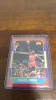 Front of Michael Jordan rookie reprint basketball card with action shot dunk.