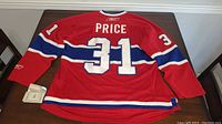 Back view of red Carey Price #31 Montreal Canadiens jersey, showing name, number and stripes.