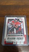 Clear view of Patrick Mahomes II football card in protective sleeve on wooden surface.