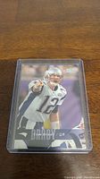 Tom Brady football trading card in protective plastic case, visible front side with player image and name.