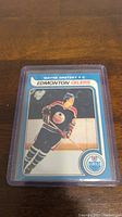 Front view of Wayne Gretzky rookie reprint hockey card showing player in Edmonton Oilers uniform inside protective plastic case.