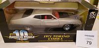 Front and side view of boxed 1:18 scale die-cast model car, showing silver 1971 Torino Cobra with black hood, red interior, and chrome wheels.