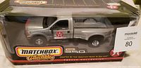 Front and side view of silver die-cast Matchbox F350 truck with Texaco logos inside original packaging.