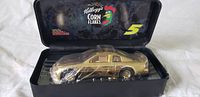 Gold 1:24 scale car inside sealed clear plastic wrap, displayed in a black Kellogg's Corn Flakes branded display box with logo and number 5.