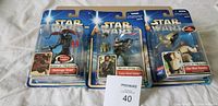 Three Star Wars Attack of the Clones figures in sealed packaging: Destroyer Droid, Clone Rebel Soldier, and Obi-Wan Kenobi.