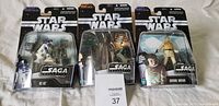 Three Star Wars The SAGA Collection action figures in original packaging: R2-D2, Boba Fett, and C-3PO & Luke Skywalker with Tauntaun. New condition visible.