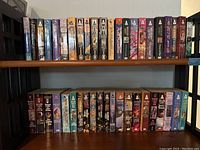 Two rows of Mercedes Lackey paperback books on shelves, showing spines with titles and colorful fantasy art.