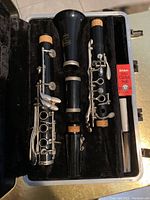 Disassembled clarinet pieces: bell, lower joint, upper joint, barrel, mouthpiece in plush-lined case with Selmer clarinet swab box