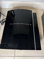 Top view of black glossy PlayStation 3 console with visible power and eject buttons
