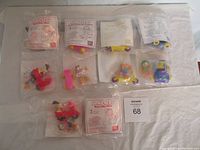 Lot of 8 Garfield collectible toys in original unopened packaging laid out on white surface.