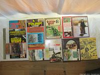 Full view of all 17 books laid out on floor showing front covers and titles related to BC pioneers and Canadian history.