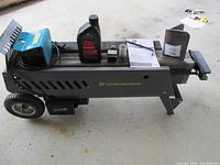 Full side view of log splitter with bottle, switch assembly, cylinder and manual on beam