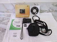 Complete lot including Canon PowerShot A1300 camera, carrying case with shoulder strap, 4GB memory card, software CD, user manual, and original packaging box.