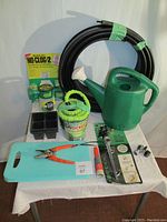 Full overview of gardening collection including hose, watering can, sprayer, starter pots, secateurs, adapters, kneeling pad, and lawn edging.