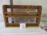 Full view of the Canadian Classics dark-stained pine wall rack showing two shelves with dimensions tape and auction card for scale.