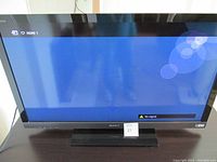 Front view of Sony Bravia TV powered on, displaying HDMI1 input with no signal message.