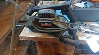 Side view of the Sears Craftsman belt sander showing the main body, front and rear handles, power cord, and branding sticker.