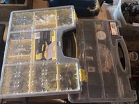 Photo of Stanley branded plastic carry box with yellow latches and many compartments containing assorted screws and small hardware items.
